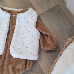 Barboteuse bébé garçon aux manches longues en velours grosse côte uni Camel avec par dessus un gilet de berger bebe une face imitation fourrure de mouton et l'autre face en double gaze à motif.