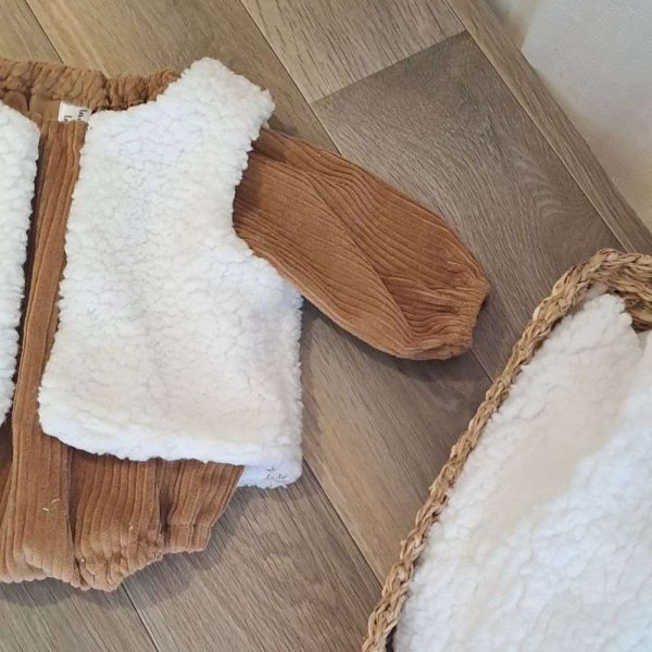 Barboteuse bébé garçon aux manches longues en velours grosse côte uni Camel avec par dessus un gilet de berger une face imitation fourrure de mouton et l'autre face en double gaze à motif en taille 6 mois