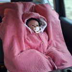 bébé en voiture dans son poncho bebe voiture évolutif pour des trajets en voiture en toute sécurité, 12-24 mois. double gaze rose pailleté